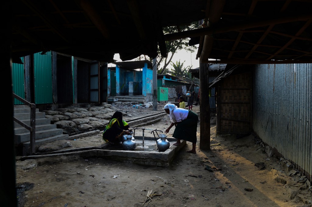 Rohingya refugee woman collect water from a tube well at Nayapara Rohingya refugee camp in Bangladesh's Teknaf district on April 6, 2018. (Munir Uz Zaman / AFP)