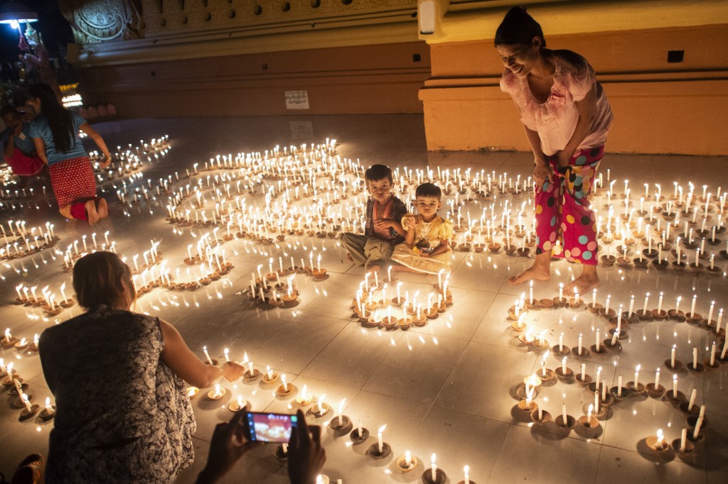 Buddhist devotees light candles at a pagoda during the Thadingyut festival in Bago last October. Thadingyut festival, the festival of Lights, is held during the full moon on the lunar month of Thadingyut and marks the end of the Buddhist Lent. (Ye Aung Thu / AFP)