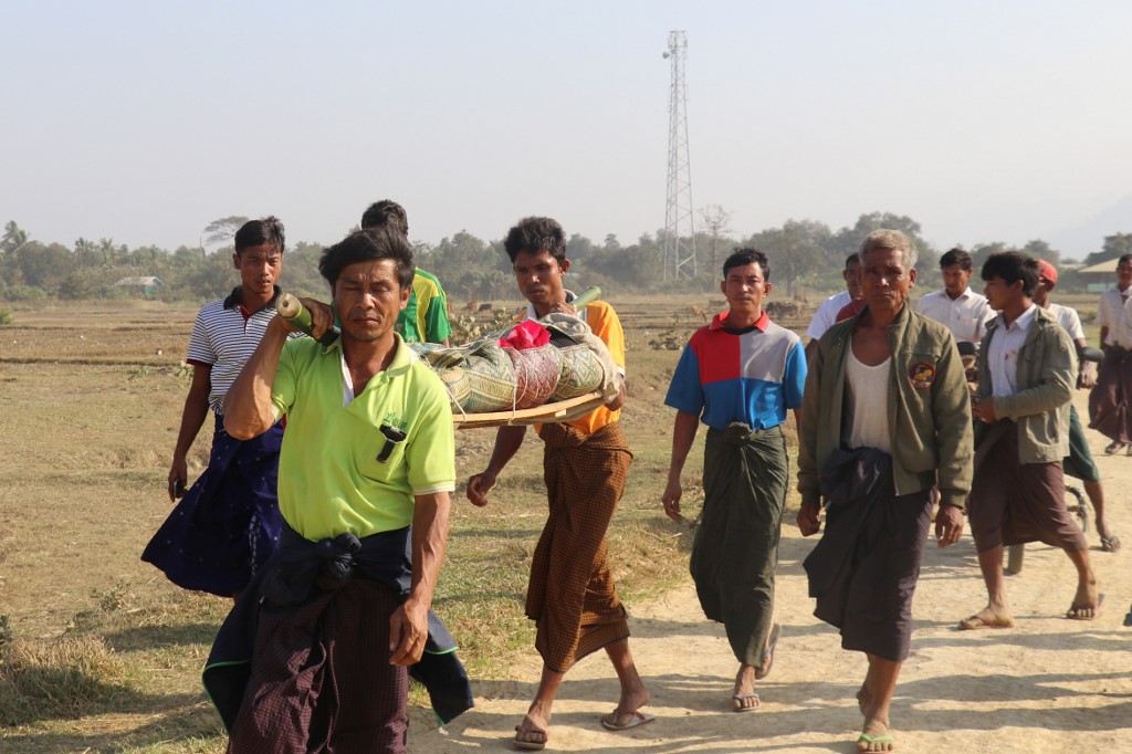 This photo taken on February 21, 2019 shows residents carrying a body of an ethnic Rakhine woman for burial in Rathedaung township after fresh fighting in Rakhine state between the Myanmar military and the Arakan Army, an ethnic Rakhine force. (AFP)