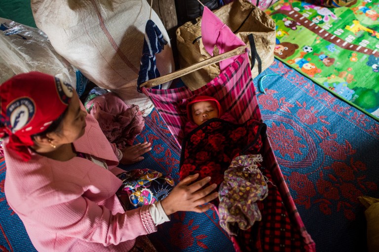 A woman sits next to her child in a monastery-turned-temporary shelter for internally displaced people (IDP) in Hsipaw, Shan State. (Ye Aung Thu / AFP)