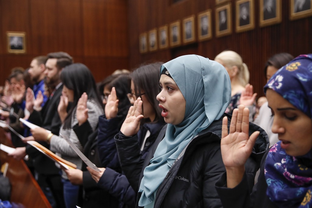 Lila Mubarak (2nd R) takes the Oath of Allegiance during a naturalization ceremony at the Everett McKinley Dirksen United States Courthouse in Chicago, Illinois on February 10, 2020. (Kamil Krzaczynski / AFP)