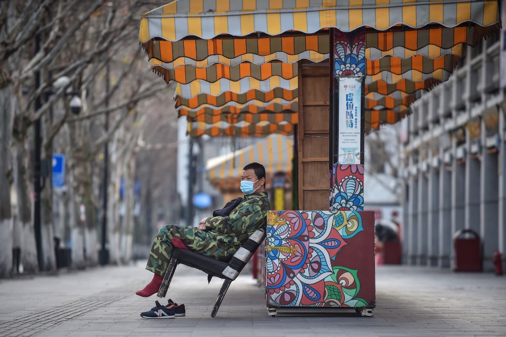  This photo taken on February 29, 2020 shows a man wearing a face mask sitting on a chair in Wuhan in China's central Hubei province. (STR / AFP)