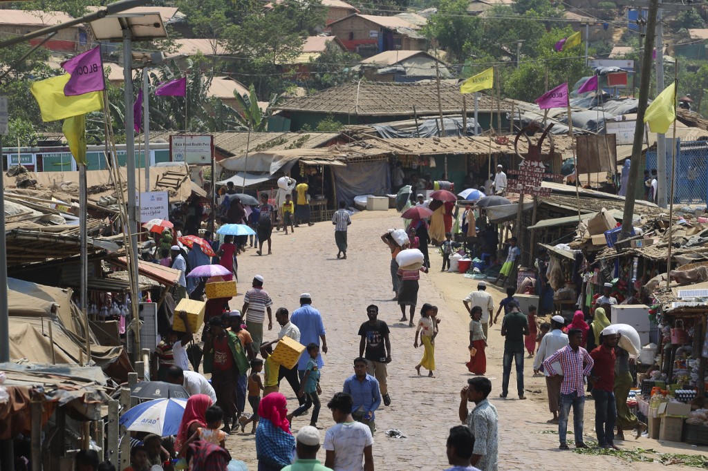 Rohingya refugees, without wearing any mask or any other safety gear as a preventive measure against the COVID-19 novel coronavirus, gather along a market area in Kutupalong refugee camp in Ukhia March 24, 2020. (Suzauddin Rubel / AFP)