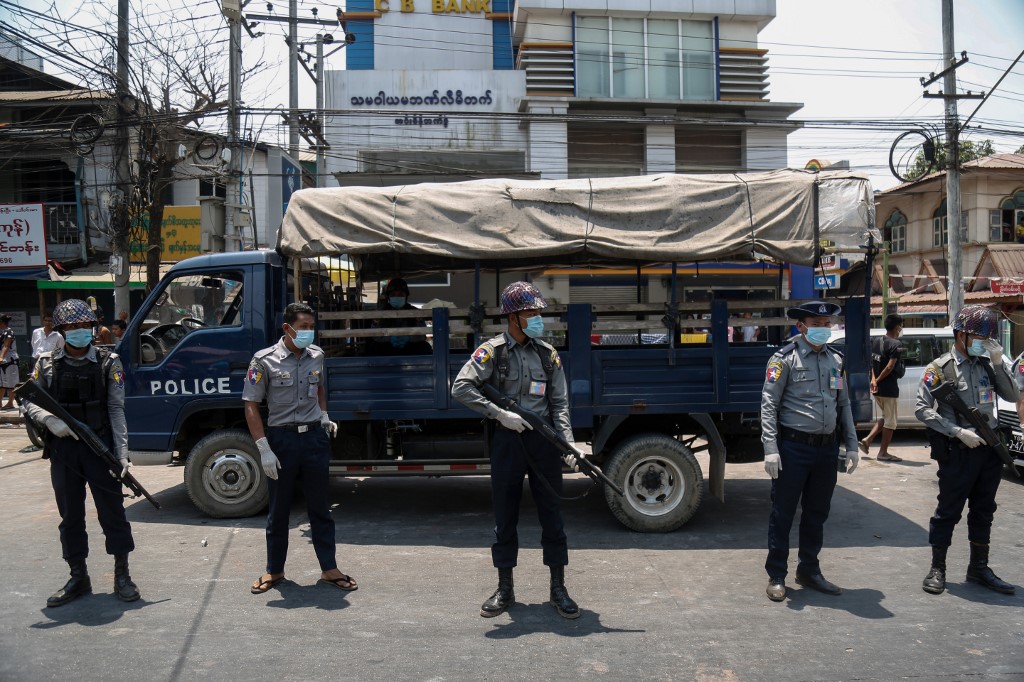 Police, wearing face masks as a preventive measure against the spread of the COVID-19 novel coronavirus, stand guard during a prisoner release in front of Insein Prison in Yangon on April 17, 2020. (Sai Aung Main / AFP)