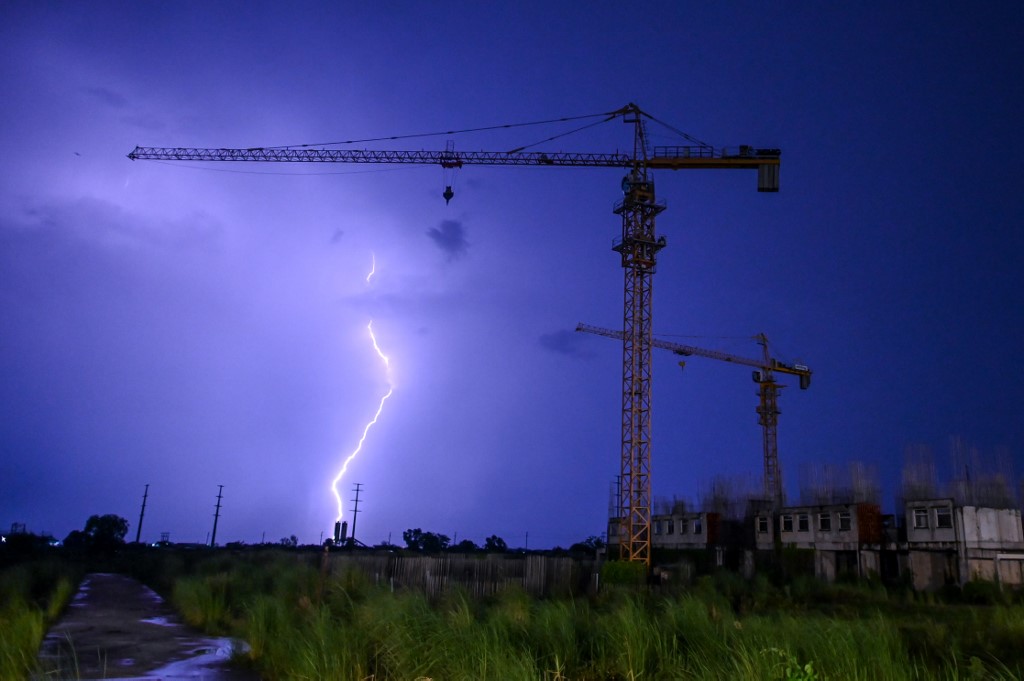 Lightning strikes over a construction site during the sunset in Yangon on June 3, 2020. (Ye Aung Thu / AFP)