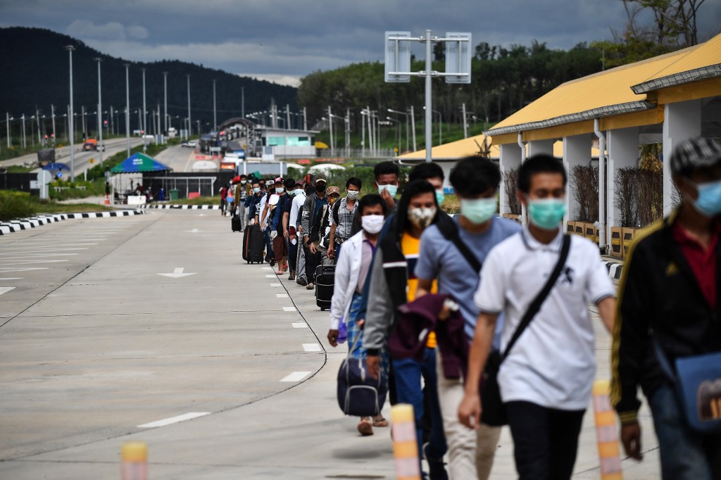 People line up to have their temperatures taken as a preventive measure against the spread of the COVID-19 novel coronavirus at the Ministry of Transport at the border crossing over the second Thailand-Myanmar Friendship Bridge in Mae Sot in Tak province on October 29, 2020. (Lillian Suwanrumpha / AFP)