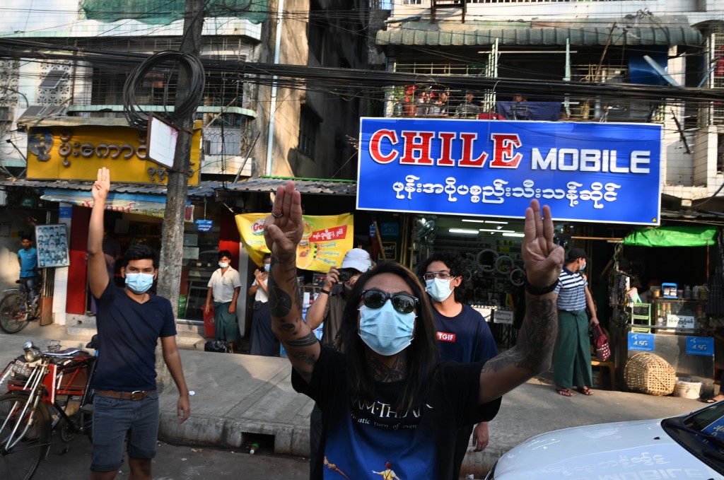 People give hold up three-finger salutes, after calls for protest against the military coup emerged on social media, in Yangon on February 4, 2021. (STR / AFP)