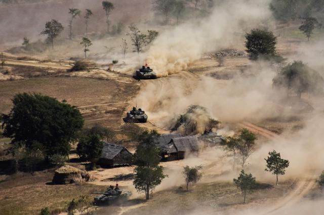 In this file photo taken on 21 January 2019 Myanmar military tanks manoeuvre in a field during combined exercise by Myanmar army and air force near Magway. (AFP)