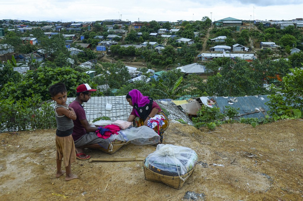 A Rohingya woman buy cloths from a vendor at Kutupalong refugee camp in Ukhia on July 24, 2019. (Munir Uz Zaman / AFP)