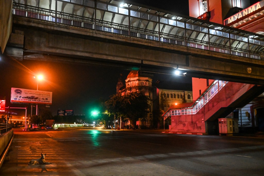 This photo taken on April 16, 2020 shows a dog (bottom L) resting on a deserted road in Yangon. (Ye Aung Thu)