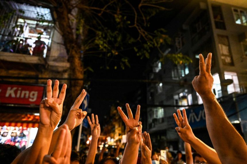 People give a three-finger salute after calls for protest went out on social media in Yangon on Feb 3, 2021 following the coup. (AFP)