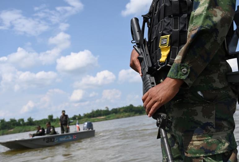 An armed Thai navy personnel riding in a boat during a patrol along the Mekong river bordering Thailand and Laos in Tha Utain, Nakhon Phanom province. (Aidan Jones / AFP)