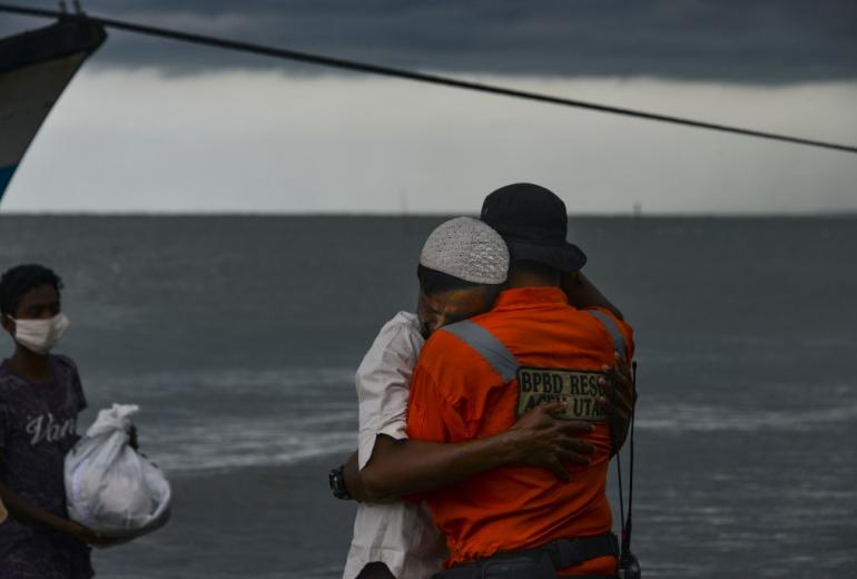 A Rohingya man from Myanmar hugs an Indonesian officer after being evacuated from a boat onto the shorelines of Lancok village, in Indonesia's North Aceh Regency on June 25, 2020. Nearly 100 Rohingya from Myanmar, including 30 children, have been rescued from a rickety wooden boat off the coast of Indonesia's Sumatra island, a maritime official said. (Chaideer Mahyuddin / AFP)