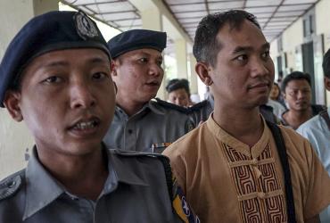 Swe Win (C), the editor of Myanmar Now, is escorted to a court by police in Mandalay on July 31, 2017. (AFP)
