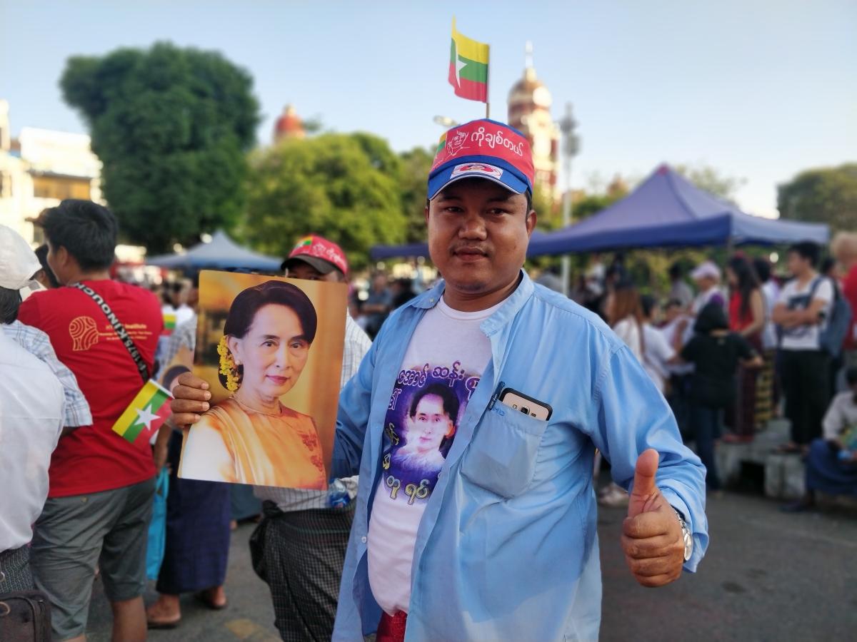 A supporter of Aung San Suu Kyi poses with a photograph of the leader. (Myanmar Mix)
